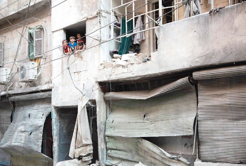 أطفال ينظرون للدمار المحيط بهم بأحد أحياء حلب