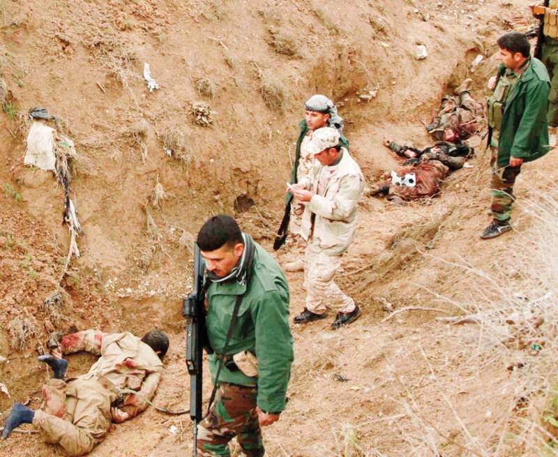 مقاتلون من البيشمركة وبجوارهم جثث لعناصر داعش في زمار بمقاطعة نيفين الكردية