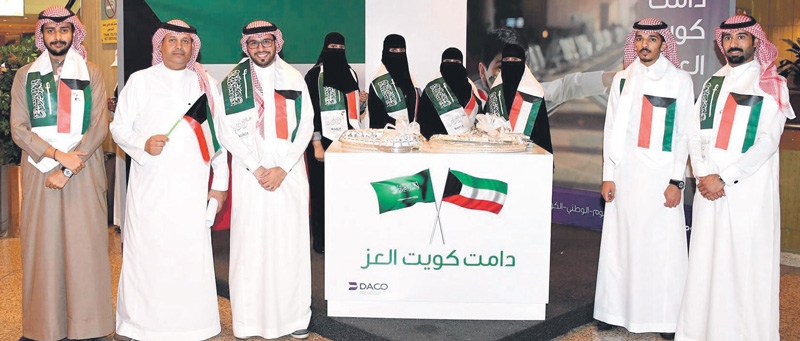 أعلام الكويت والمملكة تزين أعناق موظفي المطار (اليوم)