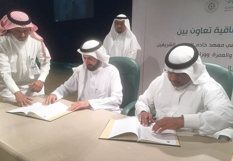 وزير الصحة خلال توقيع الاتفاقية مع مدير جامعة أم القرى