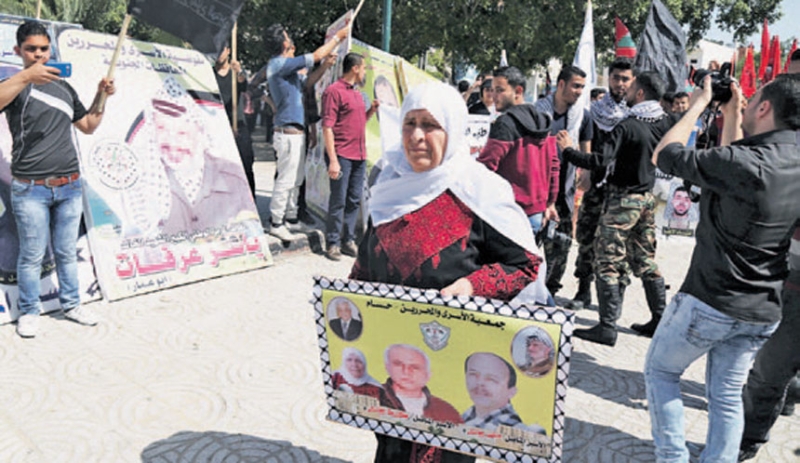 فلسطينيون بغزة يحملون صور الأسرى في احتفالات يوم الأسير