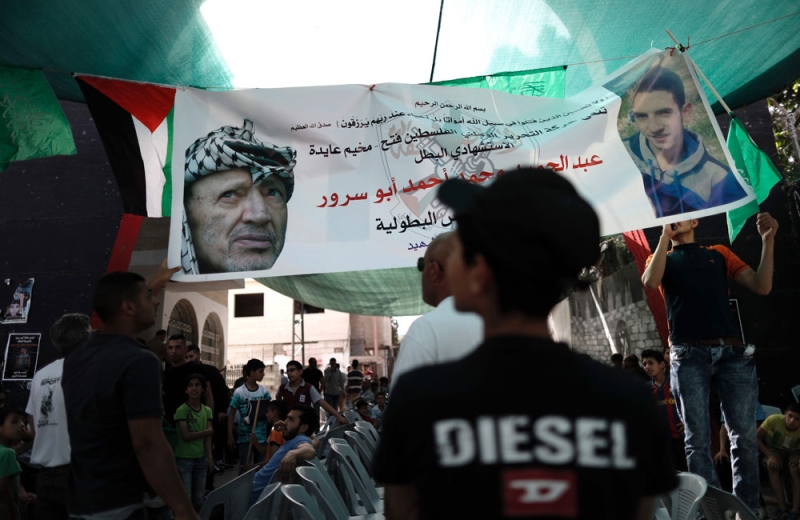 فلسطينيون يحملون صورالشهيد أبو سرور والرئيس أبوعمار