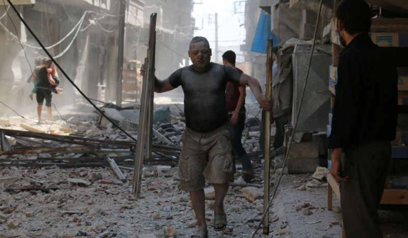 مواطنون أثناء غارة جوية استهدفت أحد أحياء حلب الواقعة تحت سيطرة المعارضة