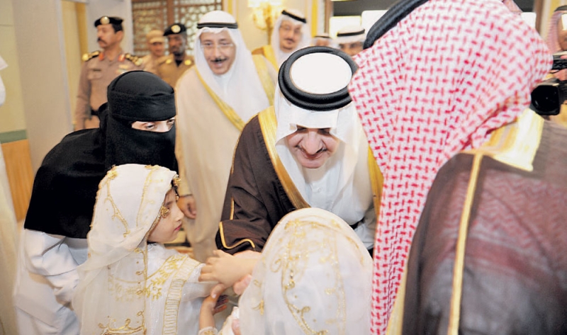الأمير سعود بن نايف يحنو على بعض الأطفال عقب افتتاح الملتقى