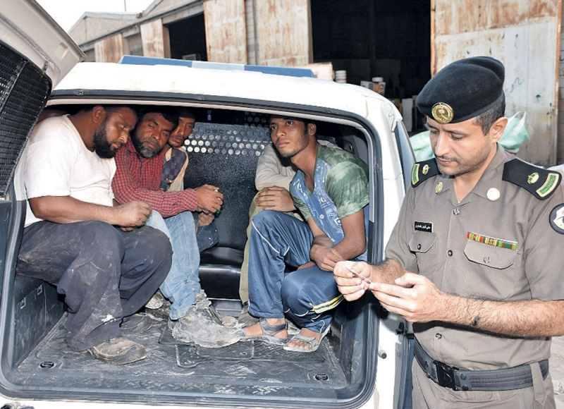 رجل أمن يتفحص أوراق أحد المقبوض عليهم (تصوير: هاني الغامدي) 