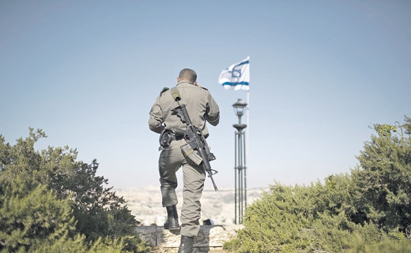 جندي إسرائيلي يراقب حركة الفلسطينيين في القدس المحتلة 
