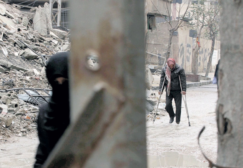  سوري يسير بين أنقاض المباني المدمرة في مدينة دوما