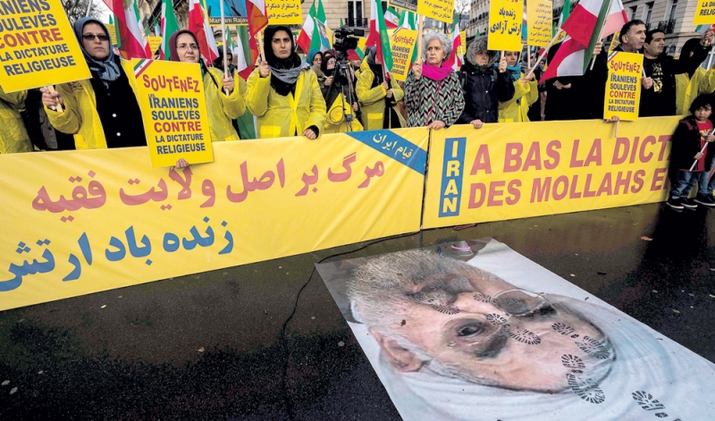 متظاهرون في باريس يحملون لافتات مناهضة لنظام الولي الفقيه دعما للانتفاضة (أ.ف.ب) 