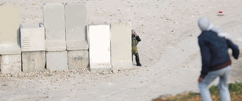 جندي إسرائيلي يستخدم الكاميرا لتصوير رماة الحجارة خلال مواجهات عند سجن عوفر بالقرب من رام الله