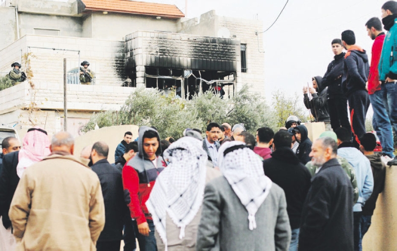 فلسطينيون يتجمعون قرب منزل أحرقه متطرفون يهود قرب رام الله