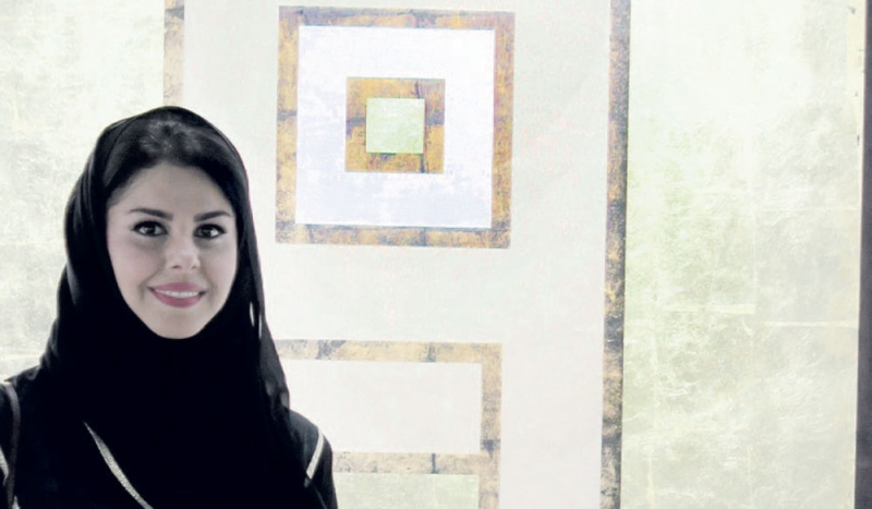  ( الحمود) أمام أحد أعمالها في ملتقى الدوحة للفنون البصرية