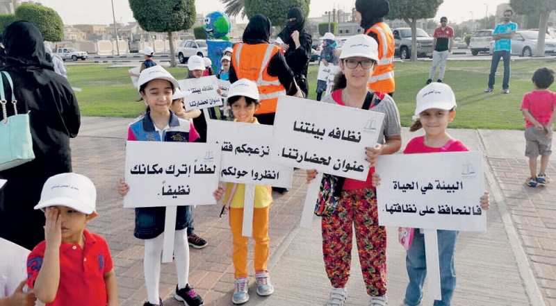  أطفال يحملون لافتات توعوية بأهمية النظافة لمرتادي الكورنيش 