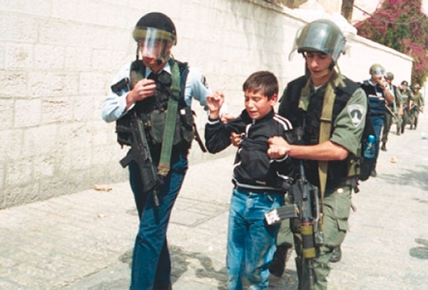 قوات الاحتلال الإسرائيلي أثناء اعتقالها فتى فلسطينيا