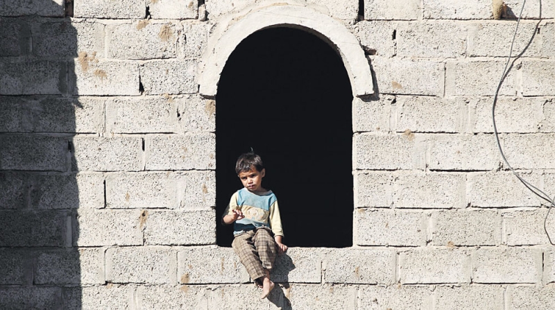 طفل يجلس في نافذة بيته بصنعاء حيث تدور المعارك على بعد 30 كلم منها 