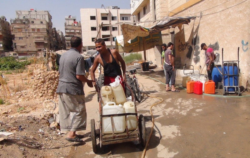 لاجئين فلسطينيين يعبؤون المياه في مخيم اليرموك (أرشيفية) 