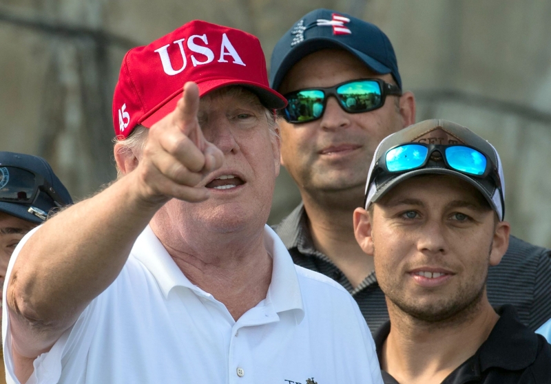الرئيس الأمريكي دونالد ترامب يتحدث مع أعضاء خفر السواحل الأمريكية خلال دعوة للعب الغولف في ملعب الغولف الدولي في مار - آلاغو فلوريدا - 29 ديسمبر 2017 (الفرنسية)