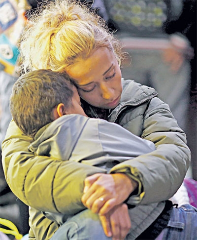 سورية تحتضن ابنها بعد وصولهما من بودابست إلى فرانكفورت