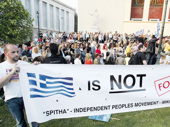 لافتة كُتب عليها «اليونان ليست للبيع» خلال مظاهرة ضد تدابير التقشف التي تريد الحكومة اليونانية تطبيقها (EPA)