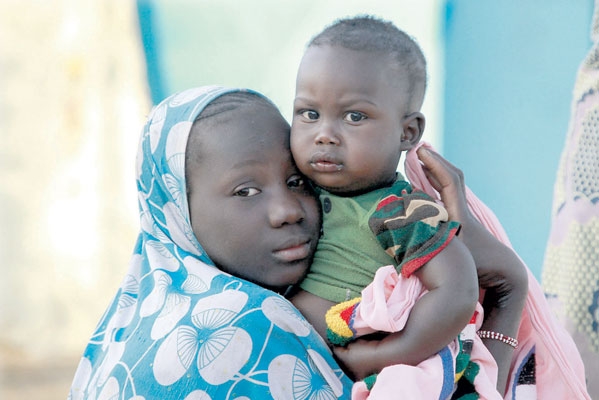 طفلة مالية تحتضن شقيقها في مخيم سيفاري . « رويترز» .