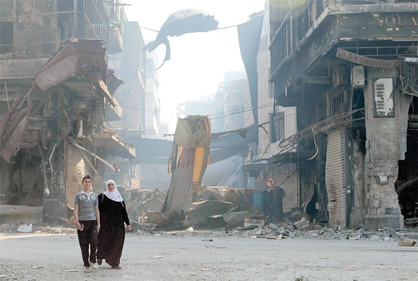  نازحون يتفقدون أنقاض منازلهم بعد عودتهم إلى حمص القديمة