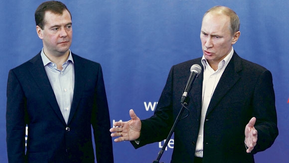 بوتين يتحدث لمؤيدي حزب روسيا المتحدة و ميدفيديف يستمع .«أ ف ب».