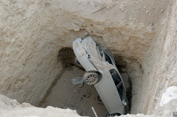 الحفرة وبداخلها السيارة ( تصوير- مرتضى بوخمسين )