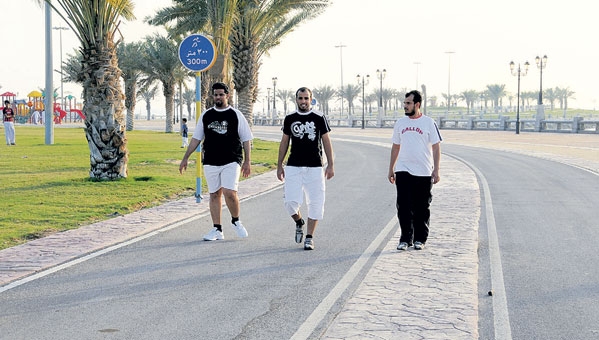 مجموعة من الشباب يمارسون رياضة المشي وآخرون يلعبون كرة القدم على كورنيش الدمام