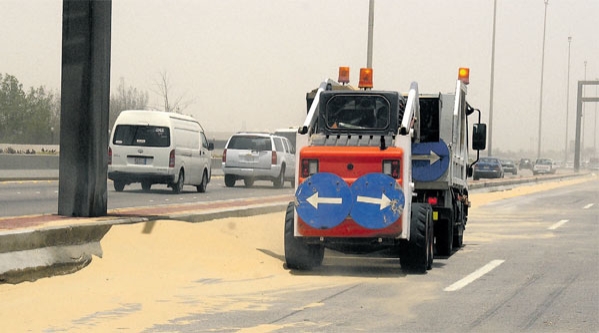 جهود لازالة كميات الرمال التي تناثرت على الطرق (تصوير : مرتضى بو خمسين)
