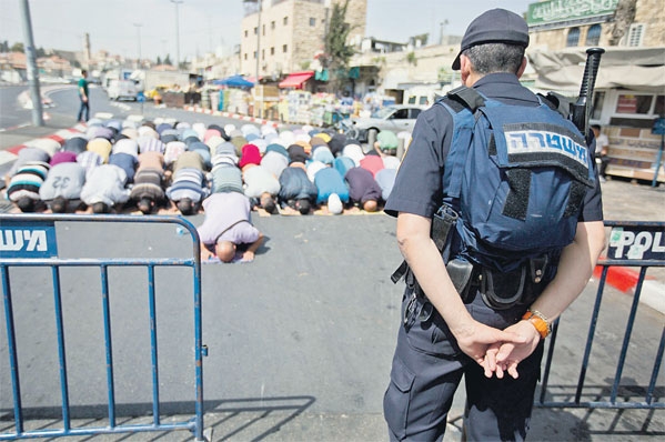 فلسطينيون يصلون في احد الشوارع عقب منعهم من دخول القدس»ارشيفية»