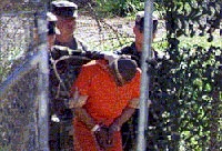  جنود أميركيون يقتادون أحد الأسرى في قاعدة غوانتانامو (أرشيف)