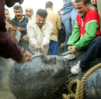 العراقيون ينهالون ضربا على رأس التمثال صدام عقب سقوطه أرضا