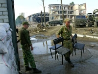 جنديان روسيان في مسرح عملية موزدوك فيما بقايا المستشفى تبدو من بعيد