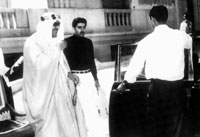 الملك سعود ويقف خلفه الدكتور الغنيم