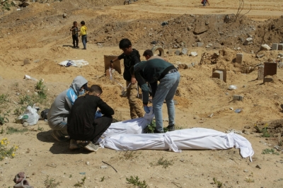Palestinians cover a body that was buried in a mass grave in the northern Gaza Strip.