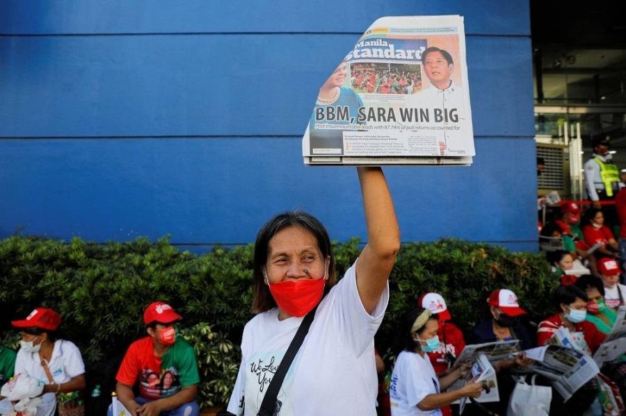 小马科斯的支持者举着一份标题是小马科斯和萨拉获胜的报纸。-路透社- 小马科斯的支持者举着一份标题是小马科斯和萨拉获胜的报纸。-路透社-