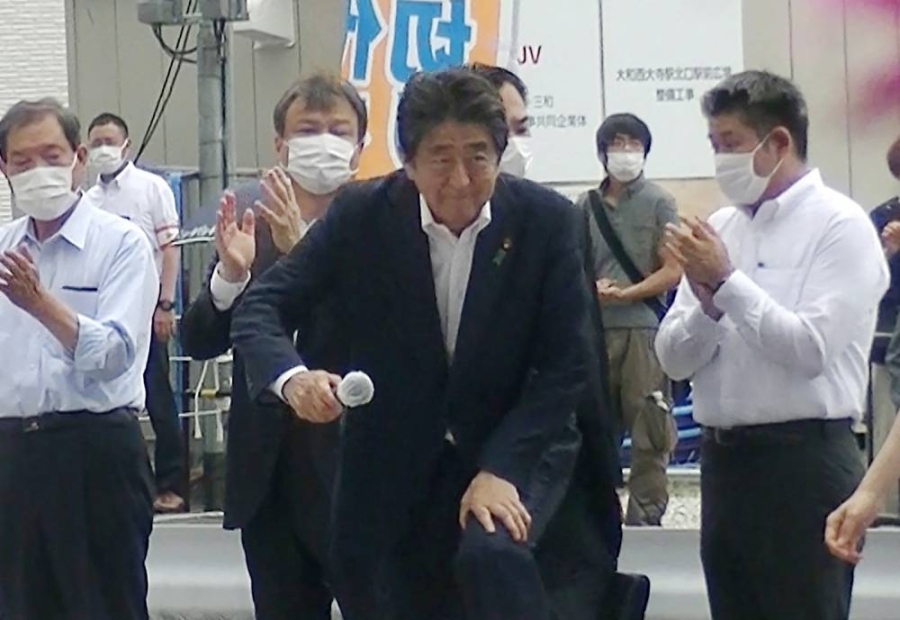 从推特上流传的影片中可见,安倍晋三(中)在演讲时,枪手山上彻也(后右,灰色上衣者)混入人群站在后方,还跟着现场民众一起拍手。-法新社- 从推特上流传的影片中可见,安倍晋三(中)在演讲时,枪手山上彻也(后右,灰色上衣者)混入人群站在后方,还跟着现场民众一起拍手。-法新社-