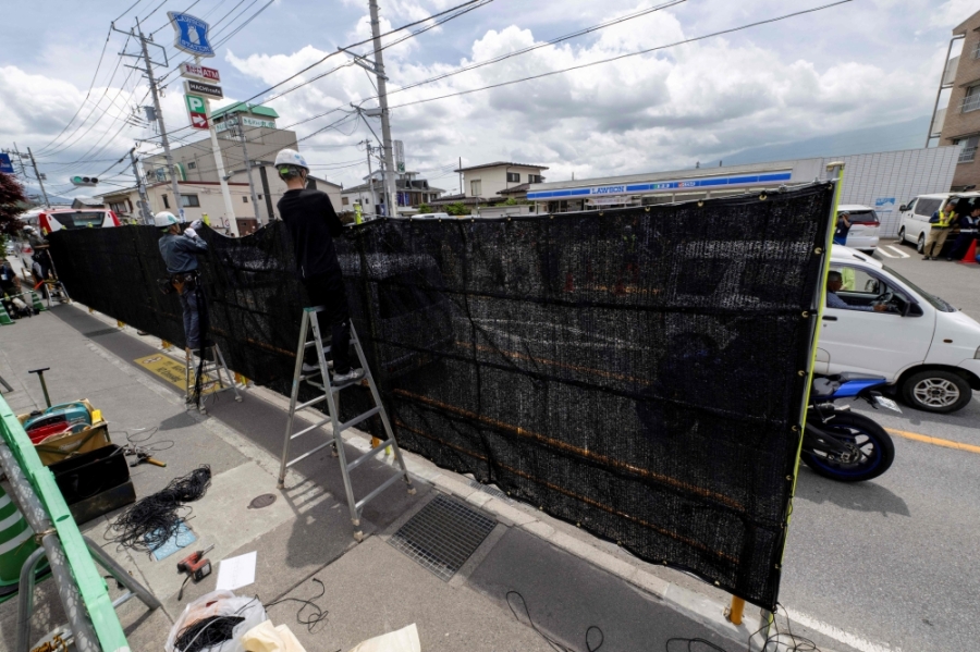 工人周二早上在便利店对面的行人路,拉起长20公尺、高2.5公尺的黑幕,固定在预先设置的铁架上。-法新社- 工人周二早上在便利店对面的行人路,拉起长20公尺、高2.5公尺的黑幕,固定在预先设置的铁架上。-法新社-