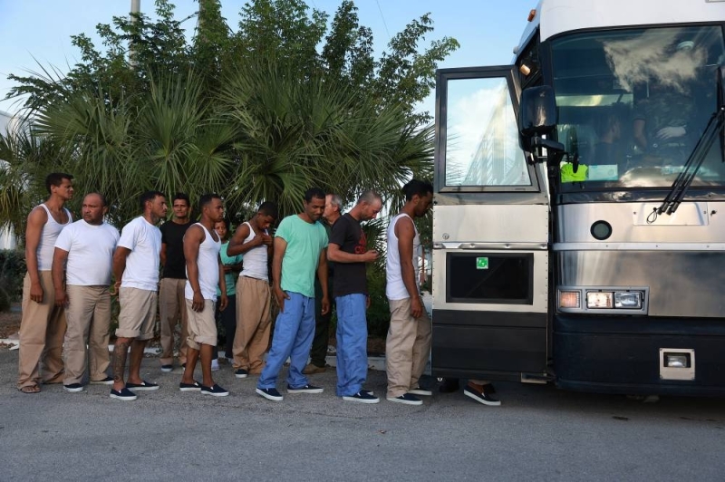 Immigrants from Cuba line up to board a bus that takes them to U.S. Customs and Border Protection during processing.  / AFP