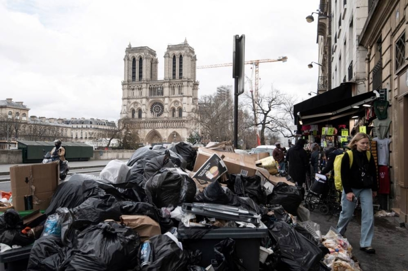 Household waste piles up on the pavement near Notre Dame Cathedral as waste collectors have been on strike since March 6 against proposed pension reforms by the French government.