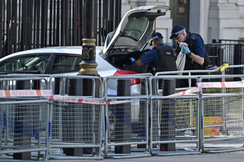 A police officer examines items in the trunk of a car driven to the gates of 10 Downing Street, the British Prime Minister's residence in central London.