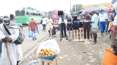 Sur les accotements servant de passage piéton, des commerçants autrefois déguerpis se sont réinstallés au grand dam des autorités municipales, obligeant les passants à risquer leur vie en côtoyant la chaussée. (Ph: Poro Dagnogo)