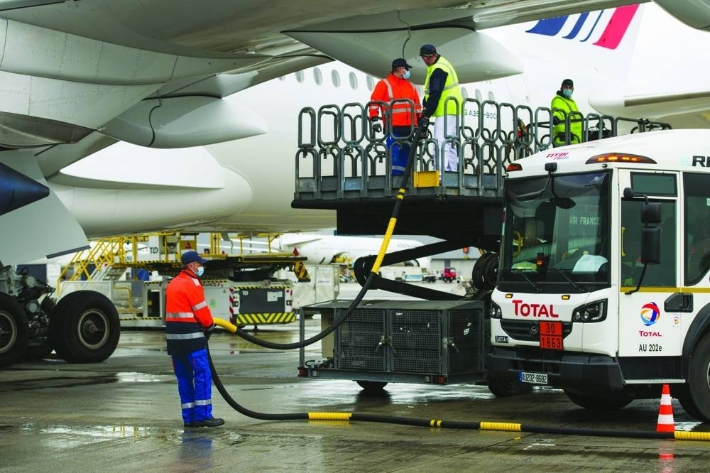 Workers connect a Total tanker truck to an Airbus A350 passenger plane, operated by Air France-KLM, during fuelling with sustainable aviation fuel (SAF) at Charles de Gaulle airport in Roissy, France. SAF is currently expected to account for 65% of carbon mitigation in 2050.
