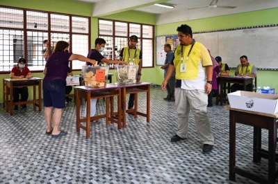 People cast their ballots at a polling station during the 15th general election in Malaysia. (AFP)