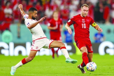 يتنافس المدافع التونسي علي عبدي ولاعب الوسط الدنماركي كريستيان إريكسن على الكرة خلال مباراة قطر 2022 عن المجموعة الرابعة على ملعب المدينة التعليمية أمس.  (أ ف ب)