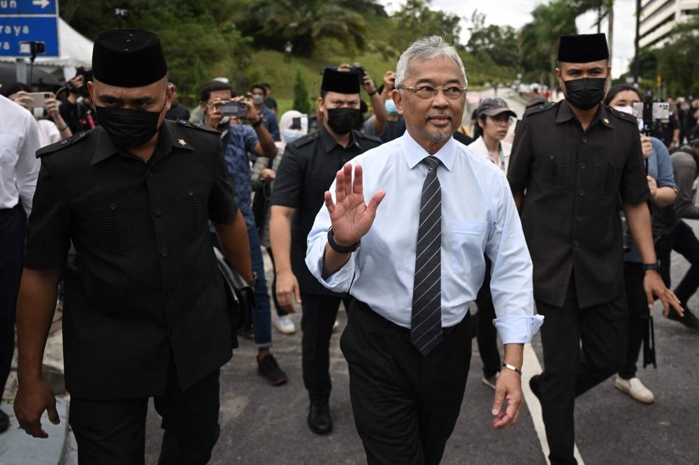 Malaysia&#039;s King Sultan Abdullah Sultan Ahmad Shah (C) waves after meeting with members of the media outside the National Palace in Kuala Lumpur (AFP)