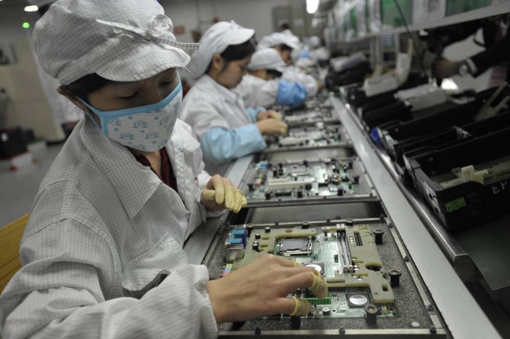 This file photo shows Chinese workers in the Foxconn factory in Shenzhen, in southern China&#039;s Guangdong province. - Violent protests have broken out around Foxconn&#039;s vast iPhone factory in central China on November 23, 2022, as workers clashed with security personnel over Covid restrictions at the plant. (AFP)