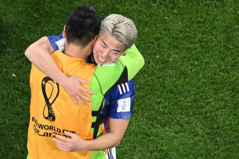 Japan&#039;s forward #18 Takuma Asano (R) celebrates with a teammate after their victory in the Qatar 2022 World Cup Group E football match between Germany and Japan at the Khalifa International Stadium in Doha.