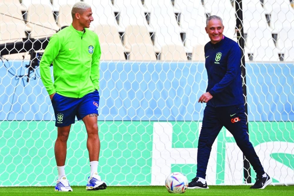 Brazil&#039;s coach Tite (R) and Brazil&#039;s forward Richarlison (L) walk on the field during a stadium familiarisation at the Lusail Stadium. (AFP)