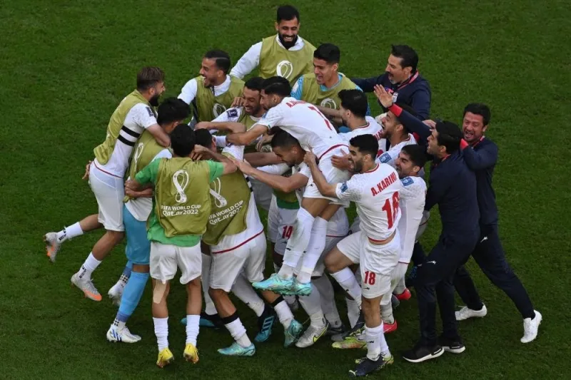 Iran&#039;s players celebrate after scoring the opening goal against Wales Friday.