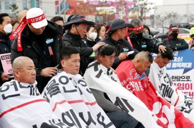 Unionised truck drivers have their hair shaved at a head-shaving protest to oppose President Yoon Suk-yeol issuing a back-to-work order for protesting truckers in Incheon (Reuters)